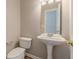 Cozy powder room featuring a pedestal sink, toilet, and light fixture, perfect for guests at 2454 Brianna Dr, Hampton, GA 30228