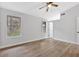 Bright bedroom featuring wood-look floors, a ceiling fan, and natural light from two large windows at 3060 Eastland Way, Snellville, GA 30078