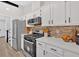 Updated kitchen boasts white cabinets, stainless steel appliances, and modern backsplash at 3060 Eastland Way, Snellville, GA 30078
