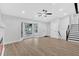 Living room features a bay window, fresh paint, modern ceiling fan, and staircase access at 3060 Eastland Way, Snellville, GA 30078