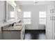 Bathroom with dual sinks, granite countertops, black tiled floors, and two large well lit mirrors at 403 Inglenook Walk, Marietta, GA 30060