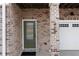 Close up of the entryway with brick surround, decorative door and garage door at 403 Inglenook Walk, Marietta, GA 30060