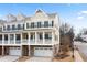 Charming yellow townhome featuring black shutters, a covered porch, and a private garage at 403 Inglenook Walk, Marietta, GA 30060