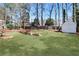 Backyard featuring an artificial turf lawn, a rock retaining wall, and a white storage shed at 5569 Snowy Orchid Dr, Sugar Hill, GA 30518