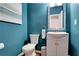 Stylish half-bath with modern fixtures and trendy teal walls at 5569 Snowy Orchid Dr, Sugar Hill, GA 30518