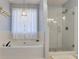 Bright bathroom featuring a soaking tub and glass shower enclosure at 5569 Snowy Orchid Dr, Sugar Hill, GA 30518