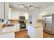 Bright kitchen featuring stainless steel appliances, white cabinetry, hardwood floors, and granite countertops at 5569 Snowy Orchid Dr, Sugar Hill, GA 30518