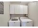 Laundry room featuring overhead cabinets, a washing machine, and a dryer at 5569 Snowy Orchid Dr, Sugar Hill, GA 30518