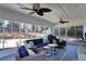 Sunroom featuring multiple ceiling fans, screened windows, and wicker furniture with blue pillows at 5569 Snowy Orchid Dr, Sugar Hill, GA 30518