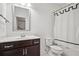 Clean bathroom showcasing a dark wood vanity, white toilet, framed mirror, and decorative shower curtain at 6838 Prelude Dr, Atlanta, GA 30328