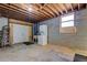 Unfinished basement featuring exposed beams, laundry area, and an egress window at 825 Sugar Creek Se Way, Conyers, GA 30094