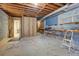 Unfinished basement with exposed ceiling, work bench and open door to a finished room at 825 Sugar Creek Se Way, Conyers, GA 30094