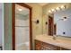 Bathroom featuring decorative wallpaper, a full bathtub-shower, a spacious vanity, and warm lighting at 825 Sugar Creek Se Way, Conyers, GA 30094