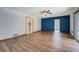 Bright bedroom featuring hardwood floors, white walls, blue accent wall, and pool access at 825 Sugar Creek Se Way, Conyers, GA 30094