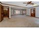 Bright living room with neutral carpet, wood trim, and large windows at 825 Sugar Creek Se Way, Conyers, GA 30094