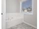 Bright bathroom featuring a soaking tub with tiled flooring and a window at 1265 Fountain Cove Ln, Lawrenceville, GA 30043