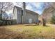 Two-story home featuring a backyard with stone patio, fire pit, and mature trees offering privacy at 1390 Bridle Path Dr, Lawrenceville, GA 30045