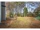 Spacious backyard featuring a stone patio with a built-in fire pit and grill area surrounded by mature trees at 1390 Bridle Path Dr, Lawrenceville, GA 30045