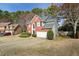 Inviting two-story house with brick facade, well-maintained lawn, and attached garage in a tree-filled neighborhood at 1390 Bridle Path Dr, Lawrenceville, GA 30045