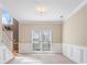 Spacious living room featuring a large window, plush carpeting, and classic wainscoting at 1390 Bridle Path Dr, Lawrenceville, GA 30045