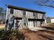 Back exterior of the home with new gray siding, a concrete patio, and a large backyard at 2728 Sandalwood Cir, Locust Grove, GA 30248