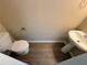 The half bath has a toilet and pedestal sink with new wood flooring and neutral colored walls at 2728 Sandalwood Cir, Locust Grove, GA 30248