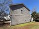 Side of the gray two-story home with a lawn and bright blue skies at 2728 Sandalwood Cir, Locust Grove, GA 30248
