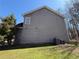 Side view of a two-story house with a gray exterior, green grass, and trees at 2728 Sandalwood Cir, Locust Grove, GA 30248