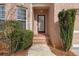 Inviting front entrance with brick steps, a decorative door, and manicured bushes at 5720 Stow Dr, Tucker, GA 30084