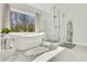 Bright bathroom with modern soaking tub and glass enclosed shower at 820 Thermopylae Ct, Alpharetta, GA 30005