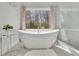 Bright bathroom featuring soaking tub and exterior views at 820 Thermopylae Ct, Alpharetta, GA 30005