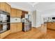 Kitchen with stainless appliances, wooden cabinets, and view into the living room for open concept living at 820 Thermopylae Ct, Alpharetta, GA 30005
