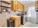 Laundry room equipped with washer, dryer, sink, storage, and shelving for efficient use at 820 Thermopylae Ct, Alpharetta, GA 30005