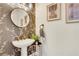 Stylish powder room featuring wallpaper, round mirror, and pedestal sink for a chic design at 820 Thermopylae Ct, Alpharetta, GA 30005