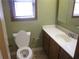 Bathroom with a tiled floor, single sink vanity, matching mirror, and standard toilet at 9165 Eves Cir, Roswell, GA 30076