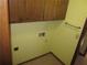 A yellow painted laundry room with overhead storage and washer/dryer hookups at 9165 Eves Cir, Roswell, GA 30076