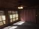 Inviting sunroom with wood paneling, ceiling fan, and natural light streaming through the windows at 9165 Eves Cir, Roswell, GA 30076
