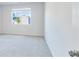 A bedroom with grey carpet and white walls has a large window providing natural light at 650 Cayenne Way, Lawrenceville, GA 30045