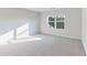 Sun-filled bedroom with grey carpet, white walls, and a large window at 650 Cayenne Way, Lawrenceville, GA 30045
