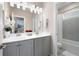 Well-lit bathroom with double vanity, stylish faucets, large mirror, and a separate room with a bathtub and toilet at 710 Hudson Way, Roswell, GA 30076