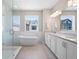 Modern bathroom featuring a soaking tub, glass shower, and double vanity with white cabinets at 710 Hudson Way, Roswell, GA 30076