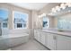 Modern bathroom featuring a soaking tub, glass shower, and double vanity with white cabinets at 710 Hudson Way, Roswell, GA 30076