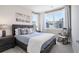 Cozy bedroom featuring a bed with a dark wood frame, side tables, and a rocking chair under a large window at 710 Hudson Way, Roswell, GA 30076