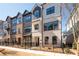 Attractive townhome exterior featuring brick and siding, a black metal fence, and manicured landscaping at 710 Hudson Way, Roswell, GA 30076