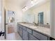 Double vanity bathroom with granite countertop, modern fixtures, and large mirror for a luxurious feel at 2300 Hopehaven Way, Hoschton, GA 30548