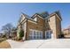 Side view of a well-maintained brick home highlighting a two-car garage with white carriage doors at 2300 Hopehaven Way, Hoschton, GA 30548