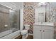 Colorful bathroom with floral wallpaper, bathtub with glass door and white vanity at 2782 Loftview Sq, Atlanta, GA 30339