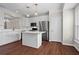 Well-lit kitchen boasts white cabinets, stainless steel appliances, a center island, and hardwood flooring at 2782 Loftview Sq, Atlanta, GA 30339