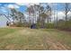 Backyard view of a tree line, and blue shelters on grass at 41 Silverthorne Ct, Douglasville, GA 30134