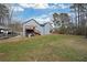 Backyard view of two-story home with a deck, stairway, fenced in area, carport, and tree line at 41 Silverthorne Ct, Douglasville, GA 30134